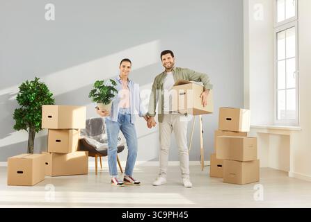 Glücklicher Umzugstag, junge Familie betritt neue Wohnung, feiert Umzug in ihr eigenes Zuhause Stockfoto