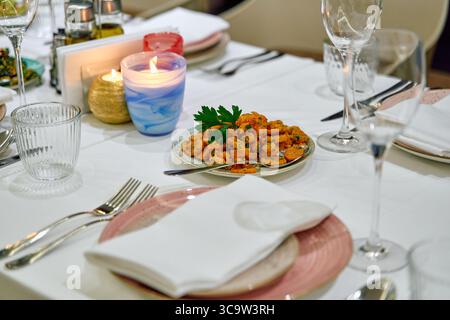 Ein eleganter Esstisch mit exquisiten Tellern und elegantem Tischdekor für ein unvergessliches kulinarisches Erlebnis Stockfoto