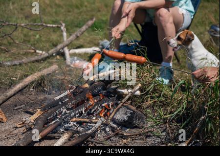 Kaukasisches Paar, das Würstchen über einem Feuer röstet. Stockfoto