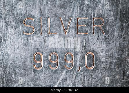 Silberner Stabstempel. Alte Silberbarren, angetrübt und zerkratzt durch Lagerung und Handhabung, in die das Wort SILBER eingeprägt wurde, und 999,0 Stockfoto