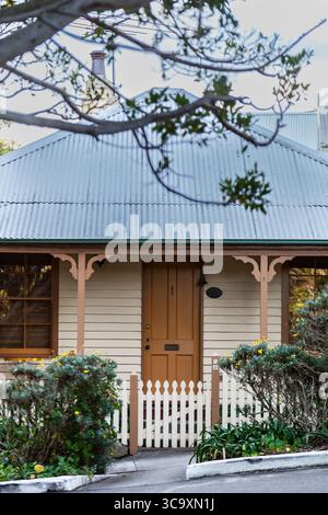Camp Cove, Watsons Bay, Sydney, Australien. 45. August 2025. Ein kleines Weatherboard Cottage hinter dem Strand in Camp Cove. Auch bekannt als Fischerhütten, einige stammen aus der Mitte des 19. Jahrhunderts. Die Blechdächer auf den kleinen Cottages in Camp Cove sind ein charakteristisches Merkmal ihres historischen und küstennahen Charmes. Stockfoto