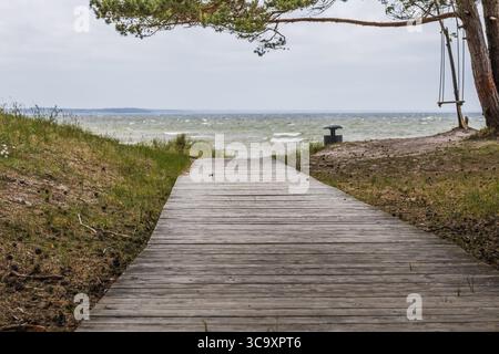 Hölzerne Promenade durch die Küstendünen führt zu windigem Blick auf den Ostseestrand Stockfoto