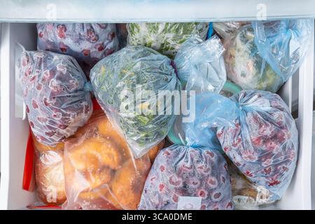 Gefrorenes Obst und Gemüse in Kunststoffbeuteln im Gefrierschrank mit frostfreiem Haushaltskonzept Stockfoto