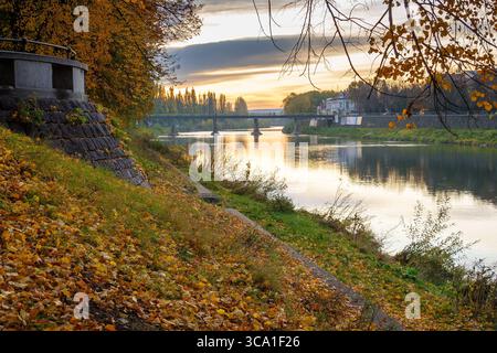 uschhorod, ukraine - 31. oktober 2009: fluss uzh bei Sonnenaufgang im Herbst. Wunderschöne Stadtlandschaft im Morgenlicht. Malerische Lindenallee in Herbstfarben. fall Stockfoto