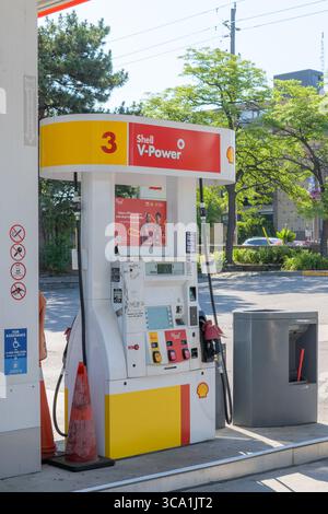 Die Shell V-Power-Gaspumpe an Station Nr. 3 verfügt über Tasten für Kraftstoffqualität, Digitalbildschirm, rote Düse und Sicherheitsschilder. Stockfoto