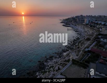 Aktau. August 2025. Eine Drohnenaufnahme vom 5. August 2025 zeigt einen Sonnenuntergang über dem Kaspischen Meer in Aktau, Kasachstan. Menschen genießen oft einen wunderschönen Blick auf den Sonnenuntergang über das Kaspische Meer in der kasachischen Hafenstadt Aktau. Quelle: Li Renzi/Xinhua/Alamy Live News Stockfoto