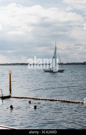 Drei Personen im Schwimmbecken mit Segelboot in Schuss, Badezone Byskoven Kopenhagen Dänemark Stockfoto