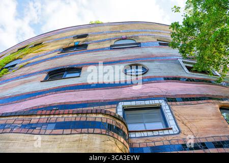 Nahaufnahme der farbenfrohen Fassade des Wohnkomplexes Waldspirale mit einzigartigem architektonischem Design und lebhaften Mosaikmustern. Stockfoto