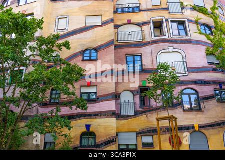 Nahaufnahme des Wohnkomplexes Waldspirale mit farbenfroher Fassade, einzigartigen architektonischen Linien und üppigem Grün in Darmstadt, Deutschland. Stockfoto
