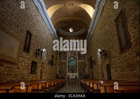 Bezaubernde Steinkirche mit historischen Gewölbedecken, verzierten Wänden und ehrfurchtsvoller Atmosphäre, die von sanftem Licht beleuchtet wird. Stockfoto