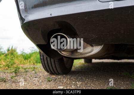 Einzelaufnahme der Metallspitze des Fahrzeugmotors neben dem hinteren Stoßfänger Stockfoto