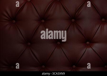 Dunkelrote Ledersofas mit dekorativen Knöpfen, strukturierte Oberfläche als Hintergrund- und Innenausstattung Stockfoto