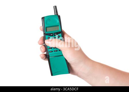 Weibliche Hand, die altes Mobiltelefon mit Antenne isoliert auf weißem Hintergrund hält. Stockfoto