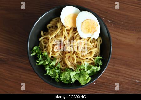 Japanische Ramen mit Ei auf schwarzer Schüssel in Nahaufnahme Stockfoto