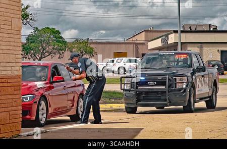 11. Mai 2023, Emporia, Kansas, USA: Der Polizeibeamte der Stadt Emporia erklärt dem Fahrer des roten BMW, warum er einen Verkehrsstopp durchführt. Der Offizier hält seine Radarkamera in der rechten Hand und zeigt sie dem Fahrer, damit der Fahrer sehen kann, wie schnell er fuhr. (Bild: © Mark Reinstein/ZUMA Press Wire) Stockfoto