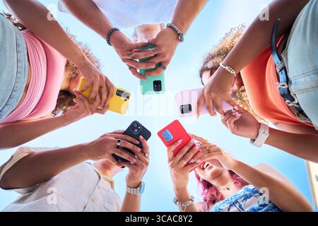 Gruppe junger Menschen, die gemeinsam im Freien Smartphones benutzen Stockfoto