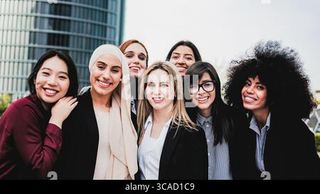 Verschiedene Gruppe von Geschäftsfrauen lächelt mit Bürogebäuden im Hintergrund Stockfoto