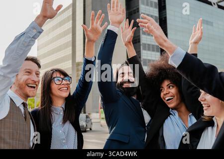 Glückliches, vielfältiges Business-Team feiert Erfolg im Freien in der Stadt Stockfoto