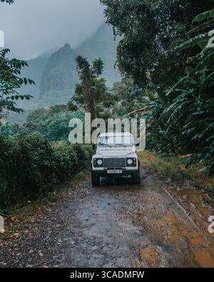 Geländefahrzeug, das bei regnerischem Wetter auf der Pineapple Road auf Moorea Island, Französisch-Polynesien, durch den tropischen Dschungel fährt Stockfoto