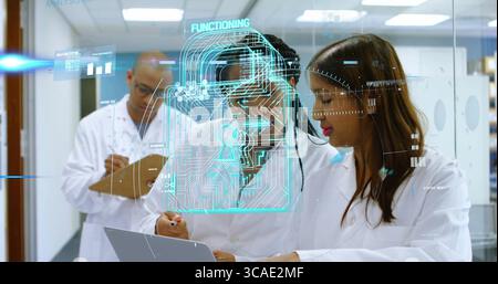 Forscher, die auf dem Laptop tippen und im Labor auf das Hologramm-Vorhängeschloss zeigen, mit Zwischenablage Stockfoto