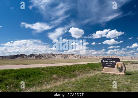 Blick auf das Eintrittsschild zum Badlands-Nationalpark in South Dakota unter einem dramatischen blauen Himmel mit Wolken Stockfoto