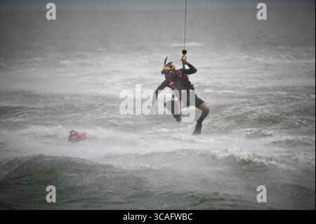 30. August 2023, Milford Haven, VA, Vereinigte Staaten: Ein United States Coast Guard Aviation Survival Technician holt während des Hebegurts in der Chesapeake Bay, 30. August 2023 in der Nähe von Milford Haven, Virginia, eine Trainingsboje ab, während er an einer Hublinie hängt. (Kreditbild: © pO2 Ryan Noel/U.S. Coast/Planet Pix via ZUMA Press Wire) Stockfoto