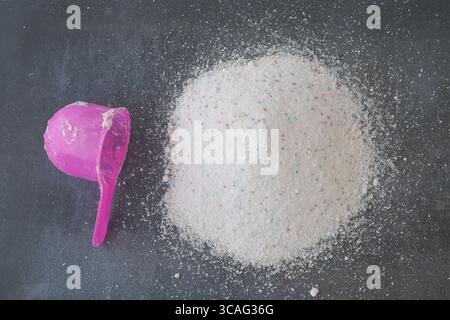 Buntes Waschmittelpulver auf dunkler Oberfläche Stockfoto
