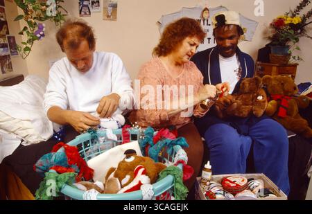 26. August 2010: In einem Hospiz in Los Angeles bejubelt ein Freiwilliger sterbende AIDS-Opfer, indem er ihnen hilft, Teddybären für Weihnachtsgeschenke zu dekorieren. Beachten Sie den Bastelsatz im Vordergrund. (Kreditbild: © Spencer Grant/ZUMA Press Wire) Stockfoto