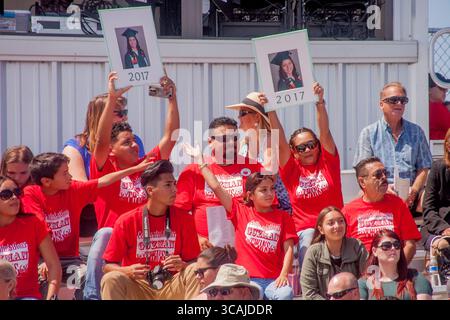 22. Juni 2017, Costa Mesa, Kalifornien: Eltern von hispanischen High School-Absolventen in roten T-Shirts Wellenporträts ihrer Kinder in traditionellen Kappen und Gewändern bei den Anfangsübungen in Costa Mesa, CA. (Credit Image: © Spencer Grant/ZUMA Press Wire) Stockfoto