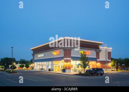 New Hartford, NY - 24. Juli 2025: Nachtblick des Tropical Smoothie Cafe, ist eine beliebte Cafés-Kette, die auf Smoothies, Speisen und Getränke spezialisiert ist Stockfoto