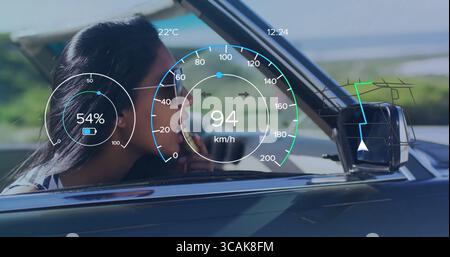 Auftragen von Lippenstift-Indianerin in Pilotensonnenbrille, die Cabrio an der Küste fährt, mit HUD-Überzug Stockfoto