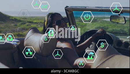 Lächelnde Frau mit Bikinis und Sonnenbrille, die sich in einem Cabrio entlang der Küste zurücklehnen lässt, mit Öko-Ikonen Stockfoto