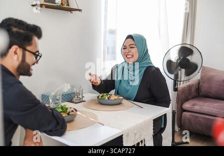 Glückliches muslimisches Paar, das zu Hause eine Mahlzeit isst Stockfoto