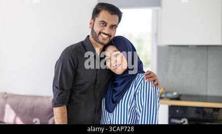 Porträt eines glücklichen muslimischen Paares, das in der Küche steht Stockfoto