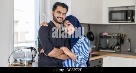 Porträt eines glücklichen muslimischen Paares, das in der Küche steht Stockfoto