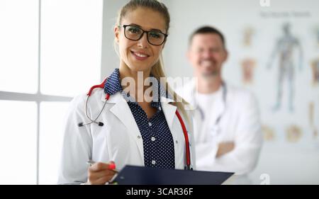 Vertrauensvolle medizinische Fachkräfte arbeiten in einer hellen Klinik zusammen und legen Wert auf Teamarbeit und Patientenversorgung Stockfoto