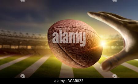 American Football Spieler werfen oder fangen den Ball während des Spiels in einem American Football Stadion. Sportbegriff Stockfoto