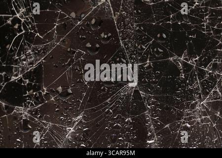 Wasser bedeckt zerbrochenes Glas auf dunklem Hintergrund, nasses Glas in viele Stücke gebrochen, Nahaufnahme Stockfoto