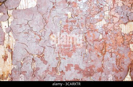 Hochauflösende Textur von rot gerissener abblätternder Farbe auf Holz. Verwitterte Oberfläche mit Flocken und tiefen Rissen. Umfasst Farbe, Schwarzweiß und verarbeitet Stockfoto
