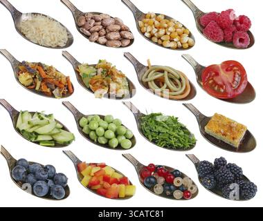 In den alten goldenen Löffeln gibt es kleine Pfähle von Nahrungssamen Körner Obst Gemüse. Isoliert auf weißem Studio Makroset Stockfoto