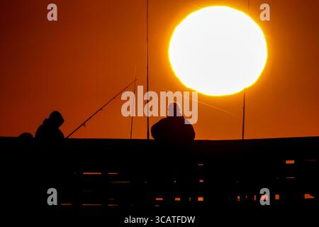 24. Oktober 2023, Isle of Palms, SC, Vereinigte Staaten: Fischer, die von Sonnenaufgang umgeben sind, warten am Isle of Palms Pier, 24. Oktober 2023 in Isle of Palms, South Carolina, auf den Fisch. (Bild: © Richard Ellis/ZUMA Press Wire) Stockfoto