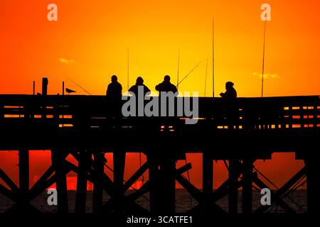 24. Oktober 2023, Isle of Palms, SC, Vereinigte Staaten: Fischer, die von Sonnenaufgang umgeben sind, warten am Isle of Palms Pier, 24. Oktober 2023 in Isle of Palms, South Carolina, auf den Fisch. (Bild: © Richard Ellis/ZUMA Press Wire) Stockfoto