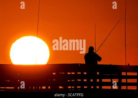 24. Oktober 2023, Isle of Palms, SC, Vereinigte Staaten: Fischer, die von Sonnenaufgang umgeben sind, warten am Isle of Palms Pier, 24. Oktober 2023 in Isle of Palms, South Carolina, auf den Fisch. (Bild: © Richard Ellis/ZUMA Press Wire) Stockfoto