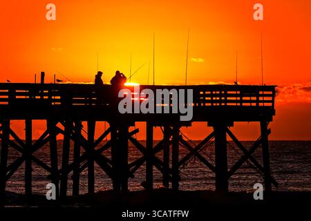 24. Oktober 2023, Isle of Palms, SC, Vereinigte Staaten: Fischer, die von Sonnenaufgang umgeben sind, warten am Isle of Palms Pier, 24. Oktober 2023 in Isle of Palms, South Carolina, auf den Fisch. (Bild: © Richard Ellis/ZUMA Press Wire) Stockfoto