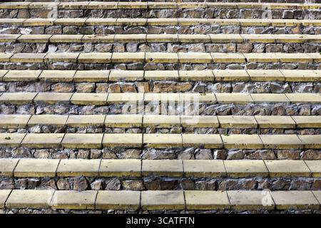 Horizontale Schritte von einer Leiter aus gelben Ziegeln und Granit Rohsteine Hintergrund Stockfoto