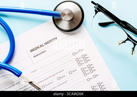 Medizin- und Gesundheitskonzept. Nahaufnahme einer Anamneseform und Arztstethoskop mit Brille Stockfoto