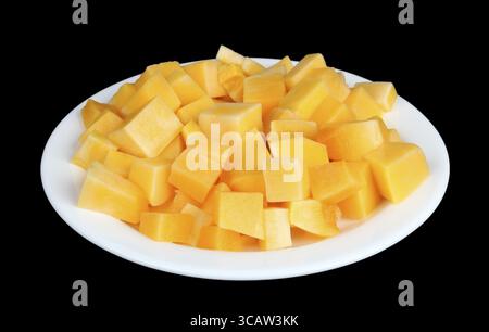 Scheiben süßer, orangener Kürbis auf einer weißen Platte. Isoliert auf schwarzem Studio-Makro Stockfoto