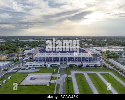 Orlando, USA - 21. Juli 2025: Aus der Vogelperspektive des Camping World Stadions sonnt sich das verblassende Licht, dessen violette Akzente im Kontrast zum üppigen Grün und der weitläufigen Stadtlandschaft stehen. Stockfoto