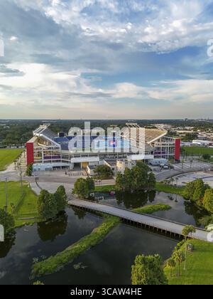 Orlando, USA - 21. Juli 2025: Aus der Vogelperspektive des Camping World Stadions, dessen leuchtend rote Säulen sich vom blauen Himmel und dem dunklen Wasser abheben. Stockfoto