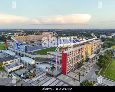 Orlando, Vereinigte Staaten - 21. Juli 2025: Aus der Vogelperspektive des Camping World Stadions, das im warmen Glanz der untergehenden Sonne getaucht ist und dessen farbenfrohe Fassade im Kontrast zum grünen Stadtbild steht. Stockfoto